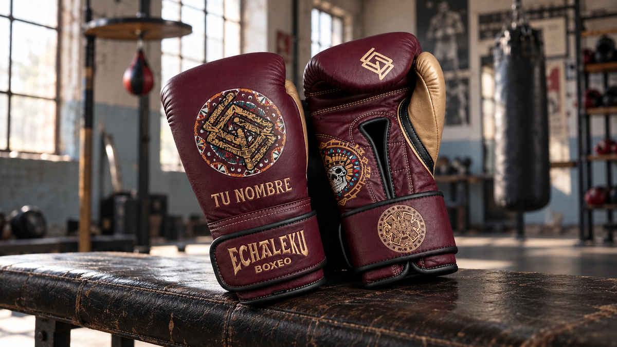 Guantes Azteca burdeos y champán de ECHALEKU BOXEO con el ejemplo de bordado TU NOMBRE, sobre un banco de gimnasio recreado.