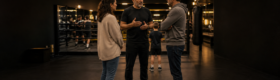Familia hablando con un entrenador antes de una clase infantil de boxeo