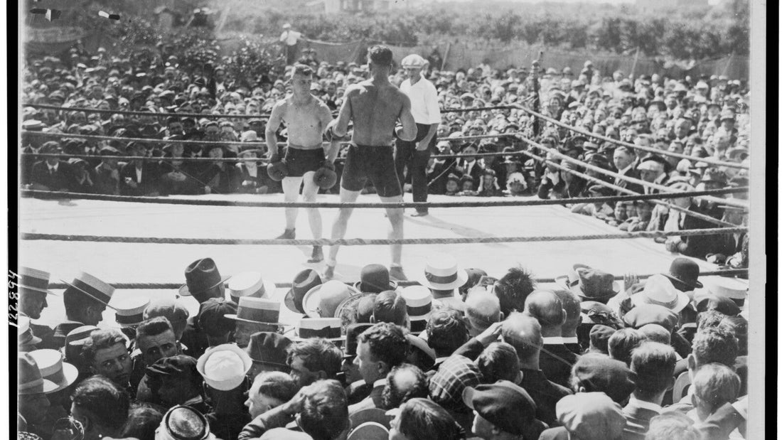 Dos boxeadores y un árbitro en un ring al aire libre ante el público