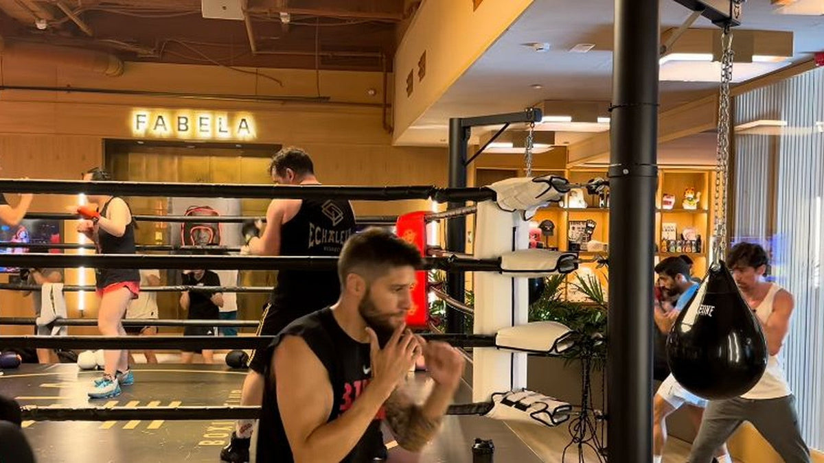Participantes practicando boxeo junto al ring y los sacos de Fabela Boxing Club.