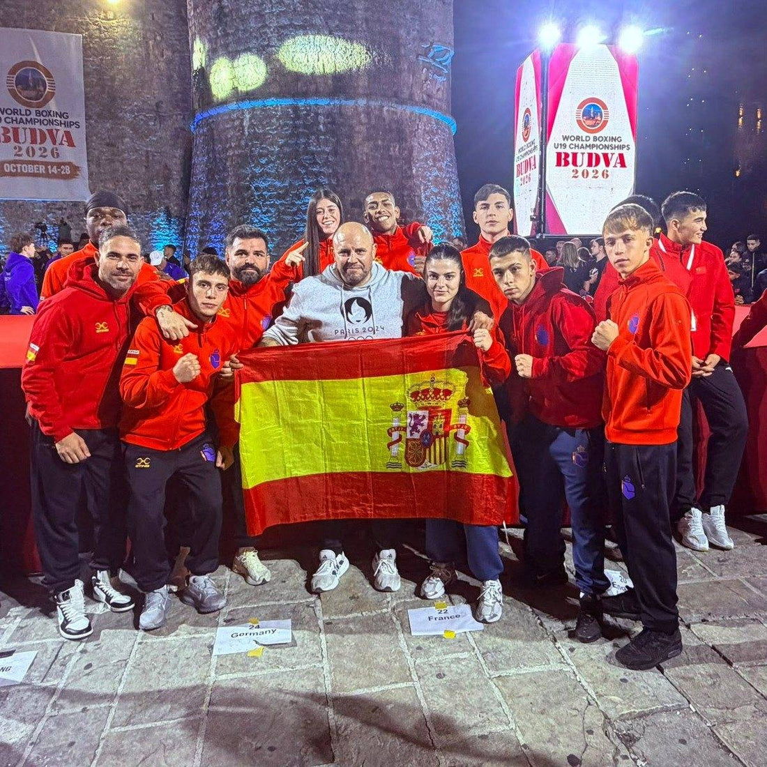 Los ocho boxeadores de la selección española U19 y su equipo de apoyo en Budva 2026, con la bandera de España. Fotografía de RFEBoxeo.
