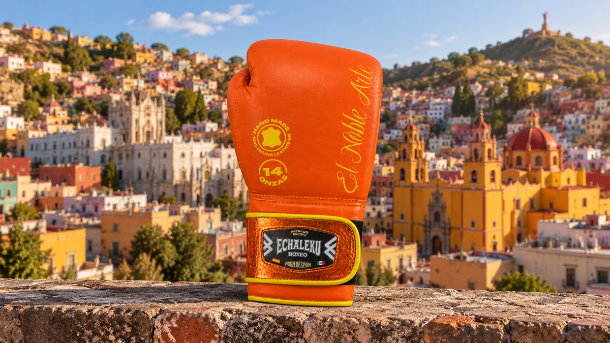 Guante Guanajuato Teja Coral de ECHALEKU BOXEO sobre piedra, ante una recreación de las casas de colores de Guanajuato.