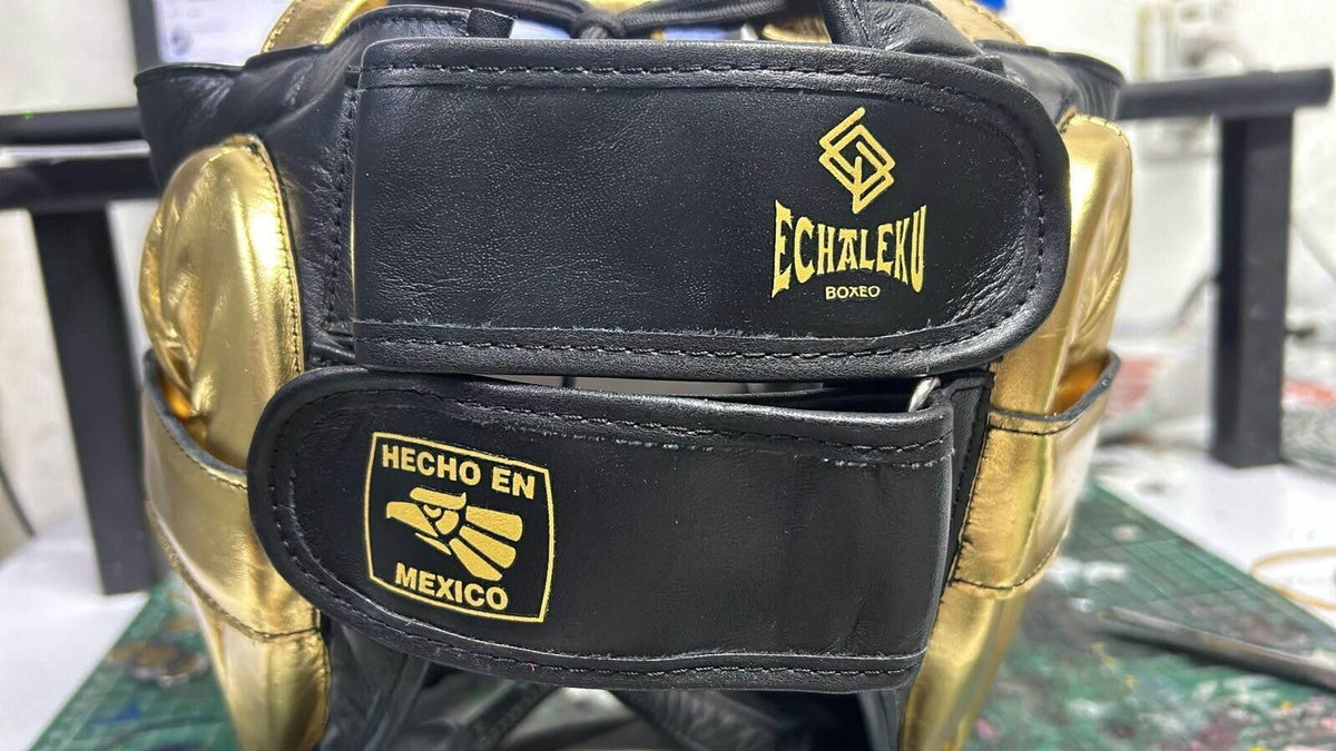 Detalle de la parte posterior y los cierres de un casco de barra Echaleku Boxeo en piel negra y dorada