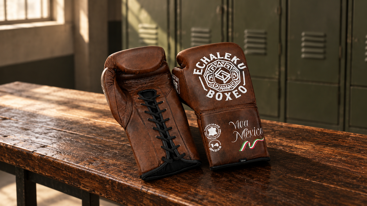 Guantes Viva México de cuerdas marrón de ECHALEKU BOXEO sobre un banco de madera en un vestuario recreado.
