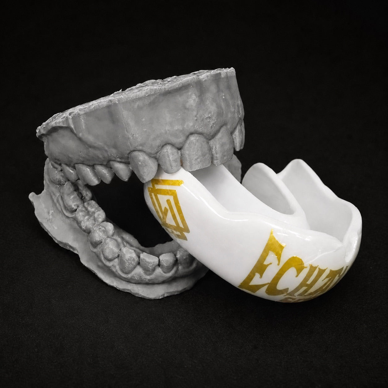 Protector bucal blanco a medida frente a molde dental gris abierto